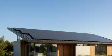 Modern home with sleek solar panels on roof under bright sun, representing sustainable energy.
